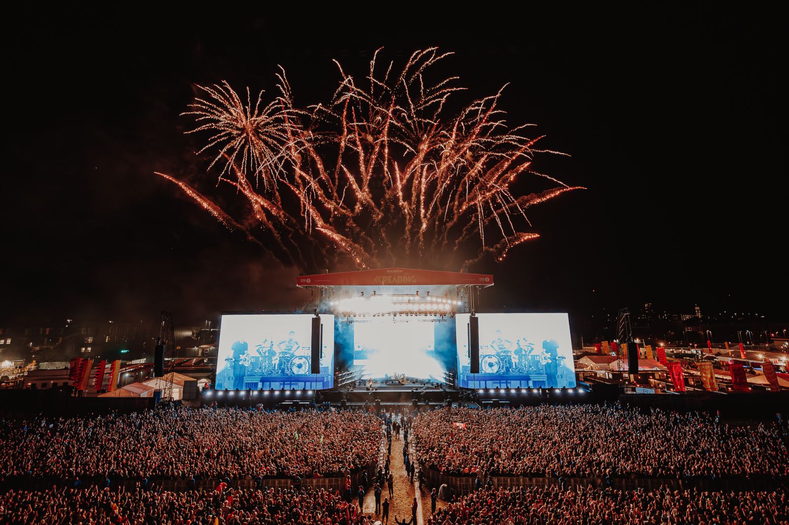 Reading Festival stage and crowd at night with firework